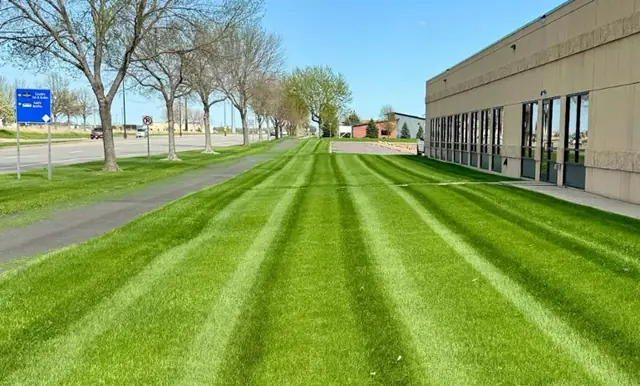 Striped commercial lawn maintained by Jason's Lawn Care