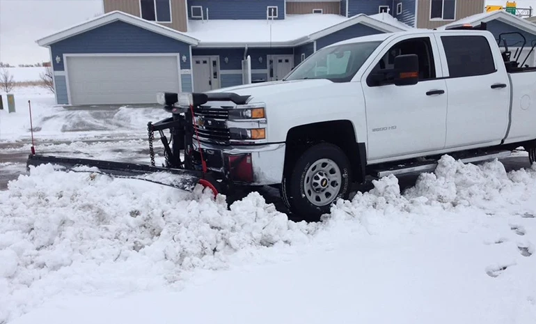 Jason's Lawn Care snow plow clearing a driveway after winter weather